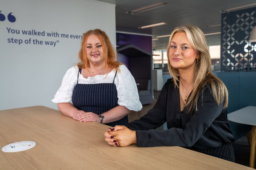 Two apprentices sit together in an office